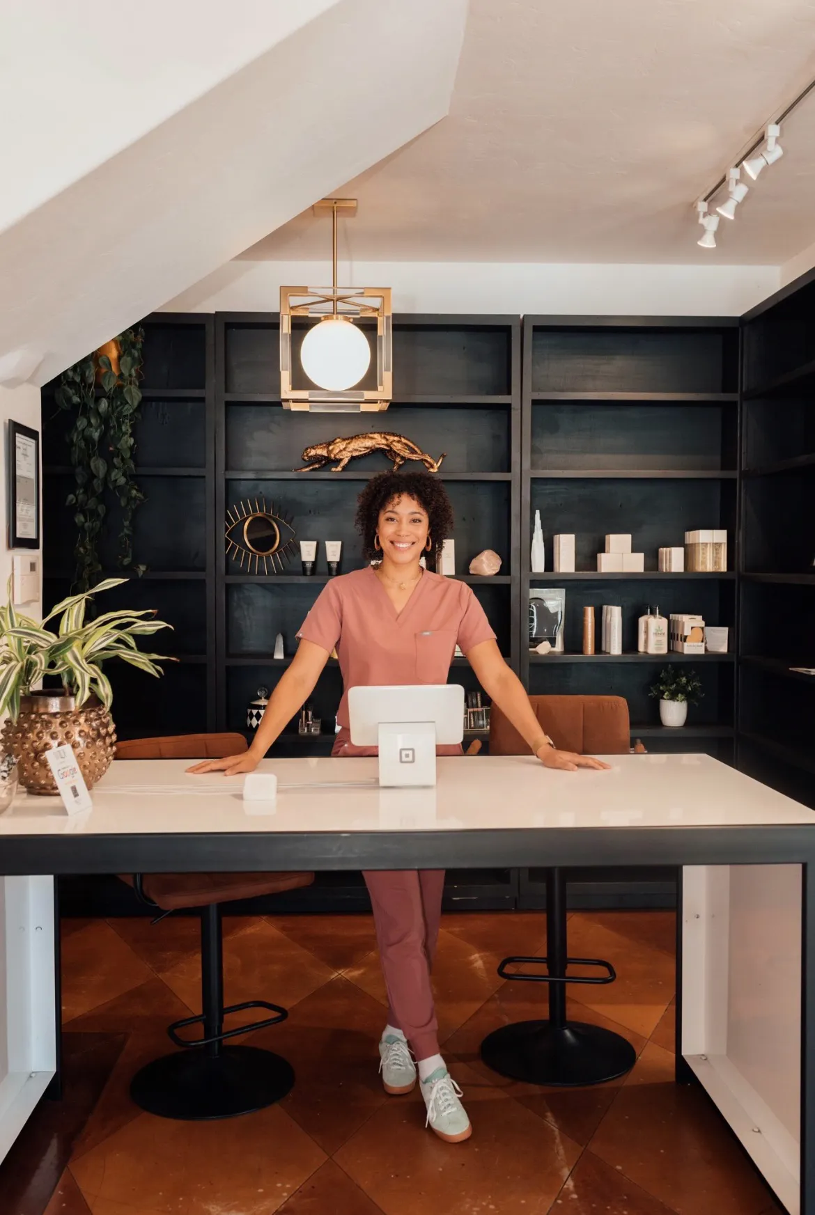 Kiki, licensed esthetician, at the front desk of the KIAMO Skin studio in Mission Hills